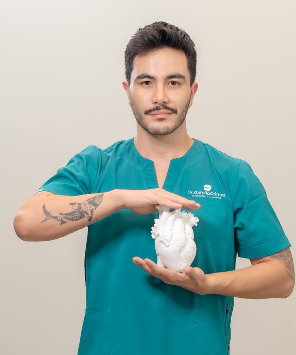 Dr. Camilo Gómez sosteniendo un modelo de corazón anatómico